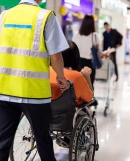 Caretaker push elderly woman on  wheelchair in airport terminal