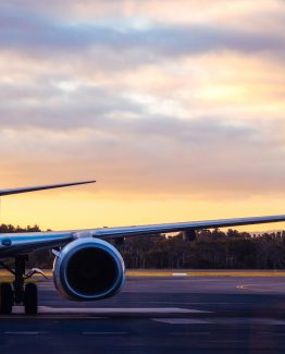 Sunset view of airplane on airport runway under dramatic sky in Hobart,Tasmania, Australia. Aviation technology and world travel concept.